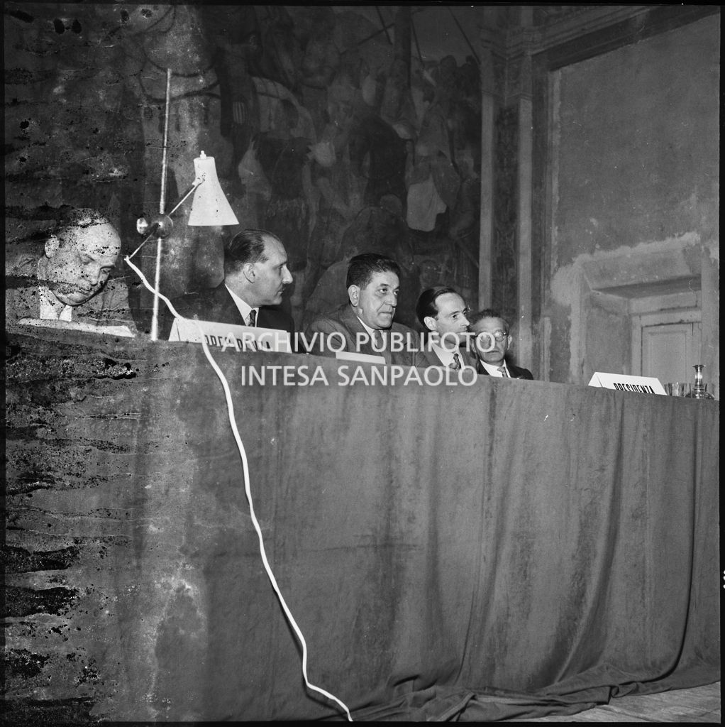 Tavolo dei relatori del convegno di studio sulle condizioni del lavoratore nell'impresa industriale organizzata nei Chiostri di San Barnaba a Milano dalla Società Umanitaria. Seduto al tavolo il segretario della CGIL Giuseppe Di Vittorio (al centro)<br>216110