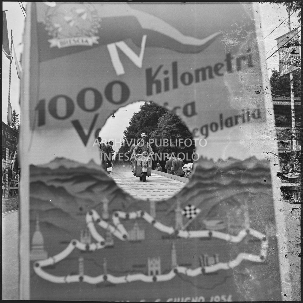 Partenza del concorrente n. 11 della competizione sportiva 1000 Km Vespistica del 1954 visto attraverso il cartellone della gara<br>216203