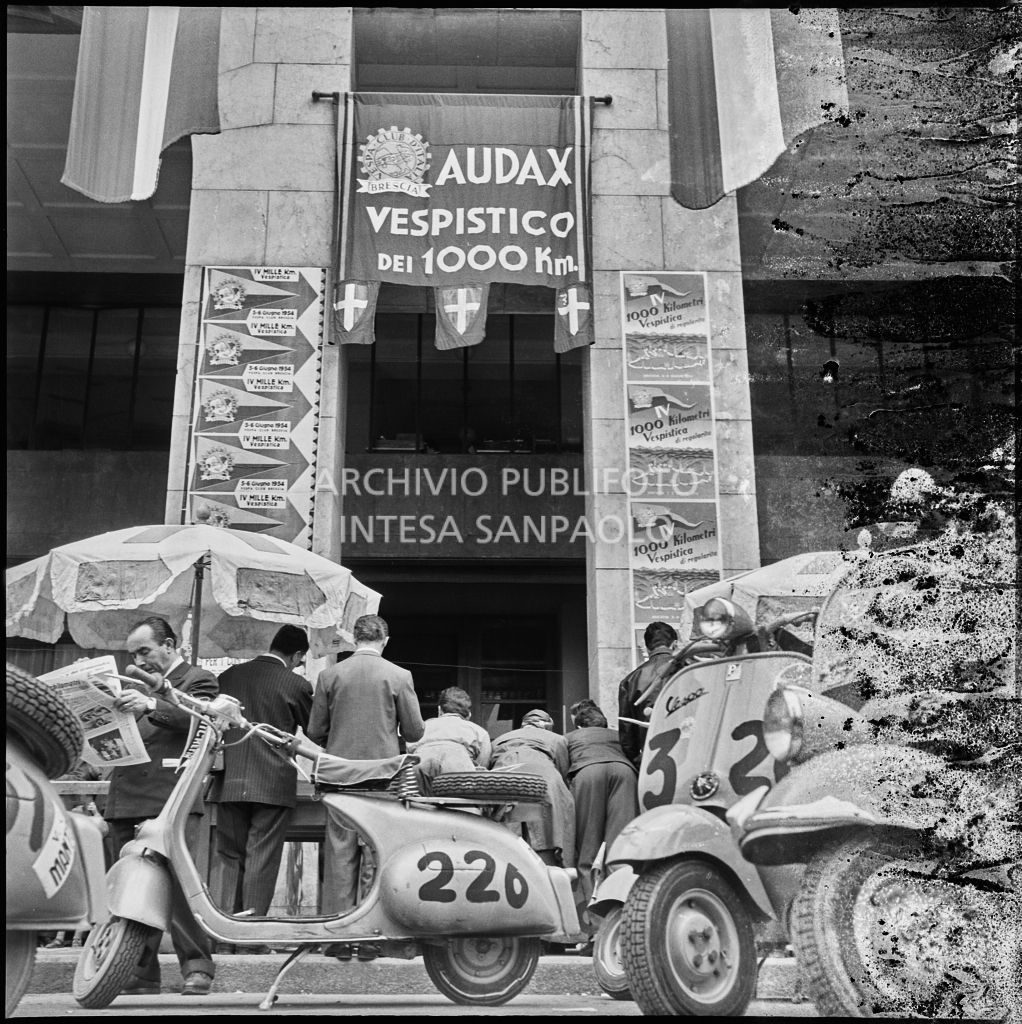 Scooter Vespa parcheggiate in piazza della Vittoria a Brescia in occasione della competizione sportiva 1000 Km Vespistica del 1954<br>216218