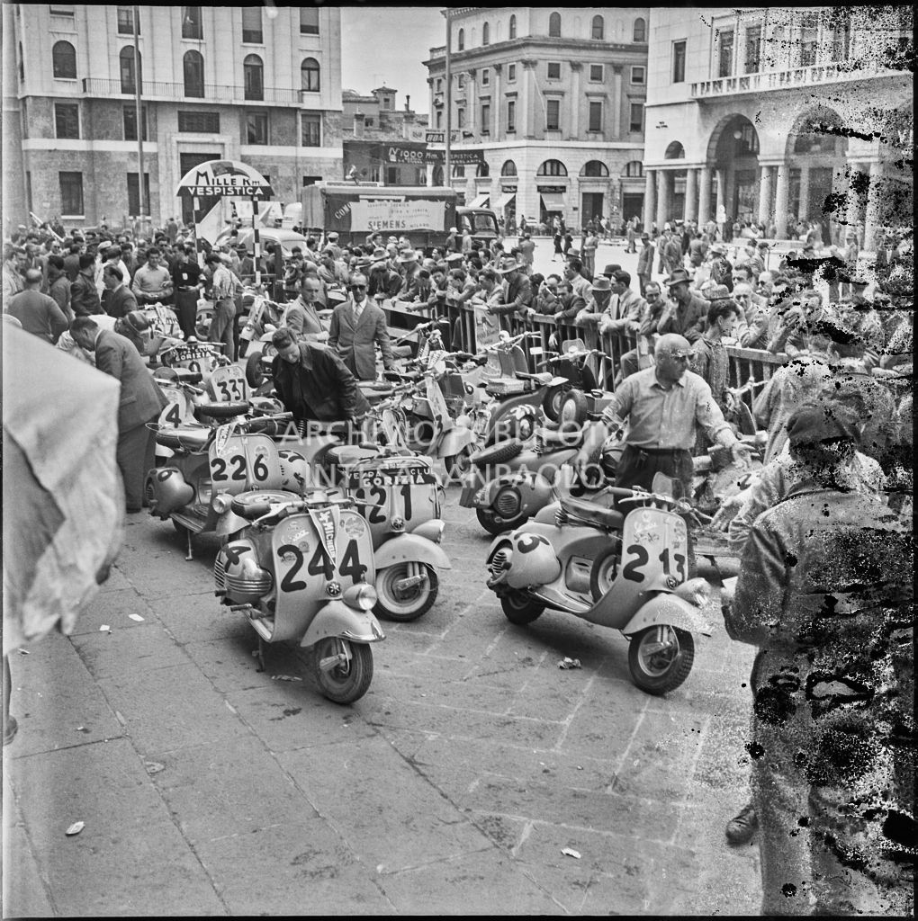 Scooter Vespa parcheggiate in piazza della Vittoria a Brescia in occasione della competizione sportiva 1000 Km Vespistica del 1954<br>216219