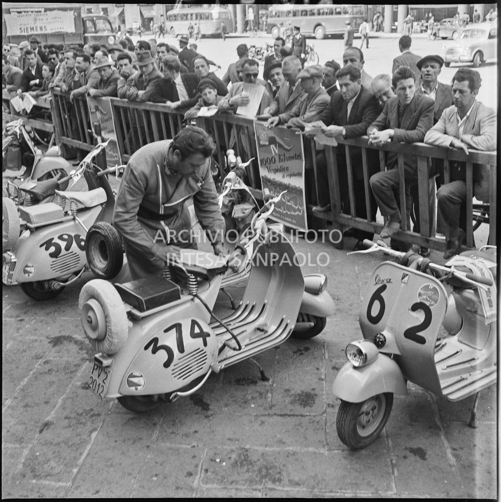 Un concorrente del Vespa Club di Vigevano (numero di gara 374) in piazza della Vittoria a Brescia in occasione della competizione sportiva 1000 Km Vespistica del 1954<br>216274