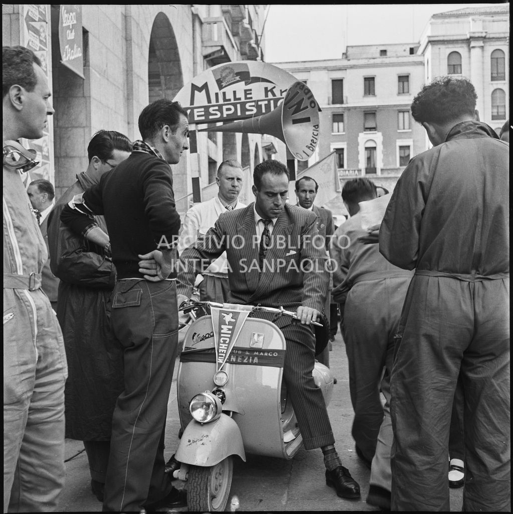 Alcuni uomini in piazza della Vittoria a Brescia in occasione della competizione sportiva 1000 Km Vespistica del 1954<br>216275