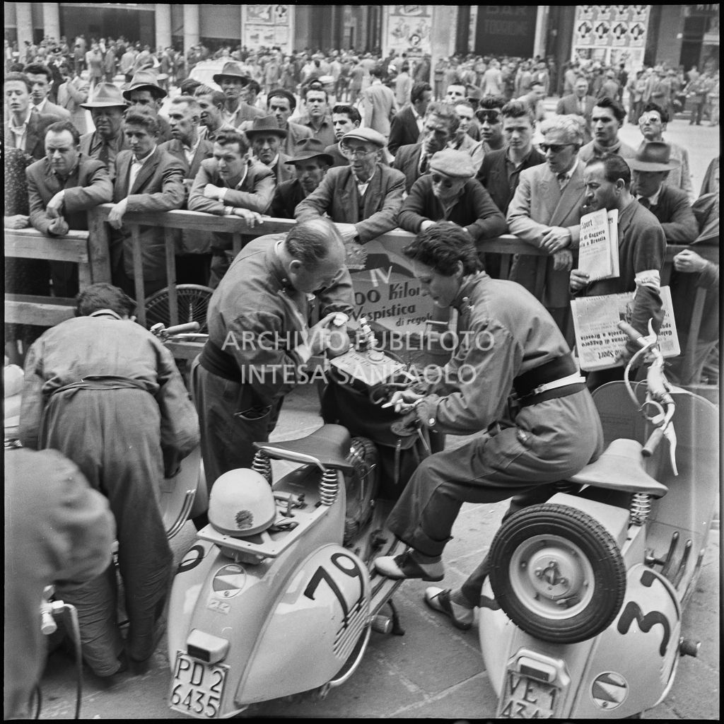 Controllo dei tempi in piazza della Vittoria a Brescia in occasione della competizione sportiva 1000 Km Vespistica del 1954<br>216284