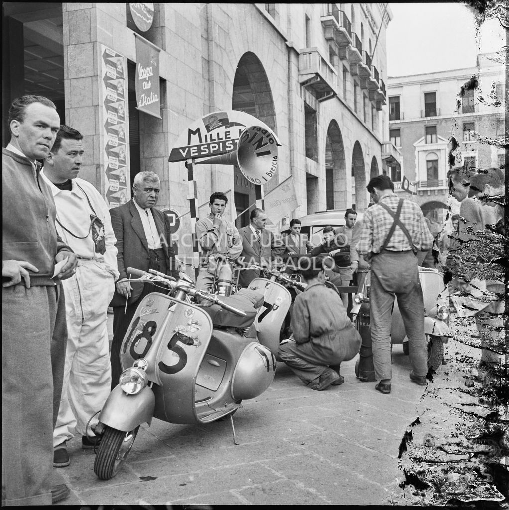 Alcuni concorrenti in piazza della Vittoria a Brescia in occasione della  competizione sportiva 1000 Km Vespistica del 1954 a Brescia<br>216312