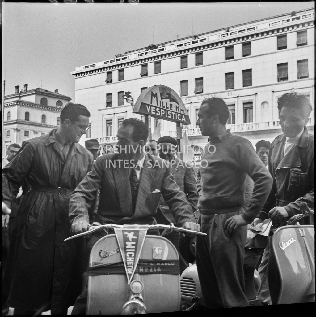 Alcuni concorrenti in piazza della Vittoria a Brescia in occasione della competizione sportiva 1000 Km Vespistica del 1954<br>216323