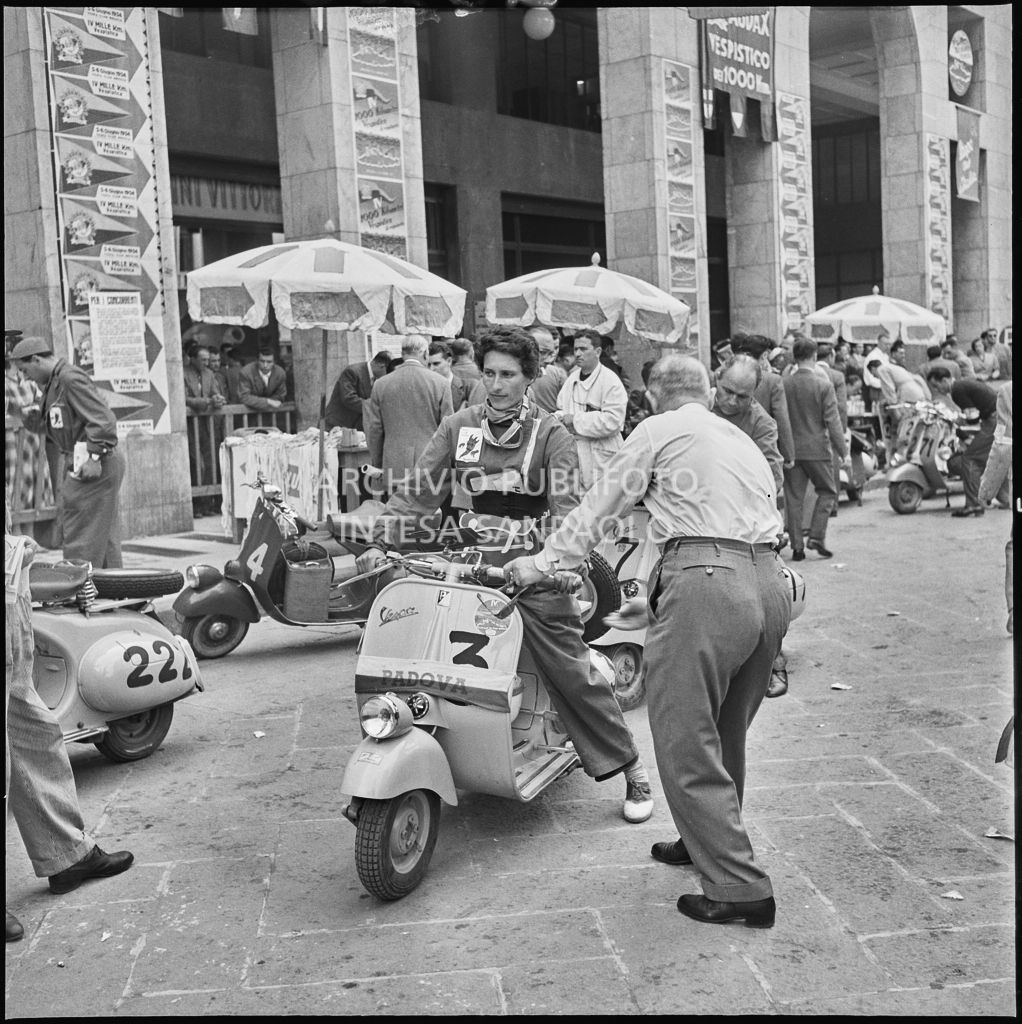 La concorrente del Vespa Club di Padova (numero di gara 3) in piazza della Vittoria a Brescia in occasione della competizione sportiva 1000 Km Vespistica del 1954<br>216326