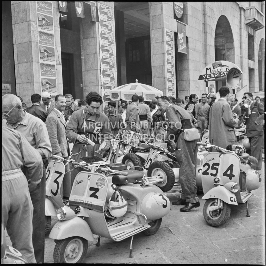 Alcuni concorrenti in piazza della Vittoria a Brescia in occasione della competizione sportiva 1000 Km Vespistica del 1954<br>216327