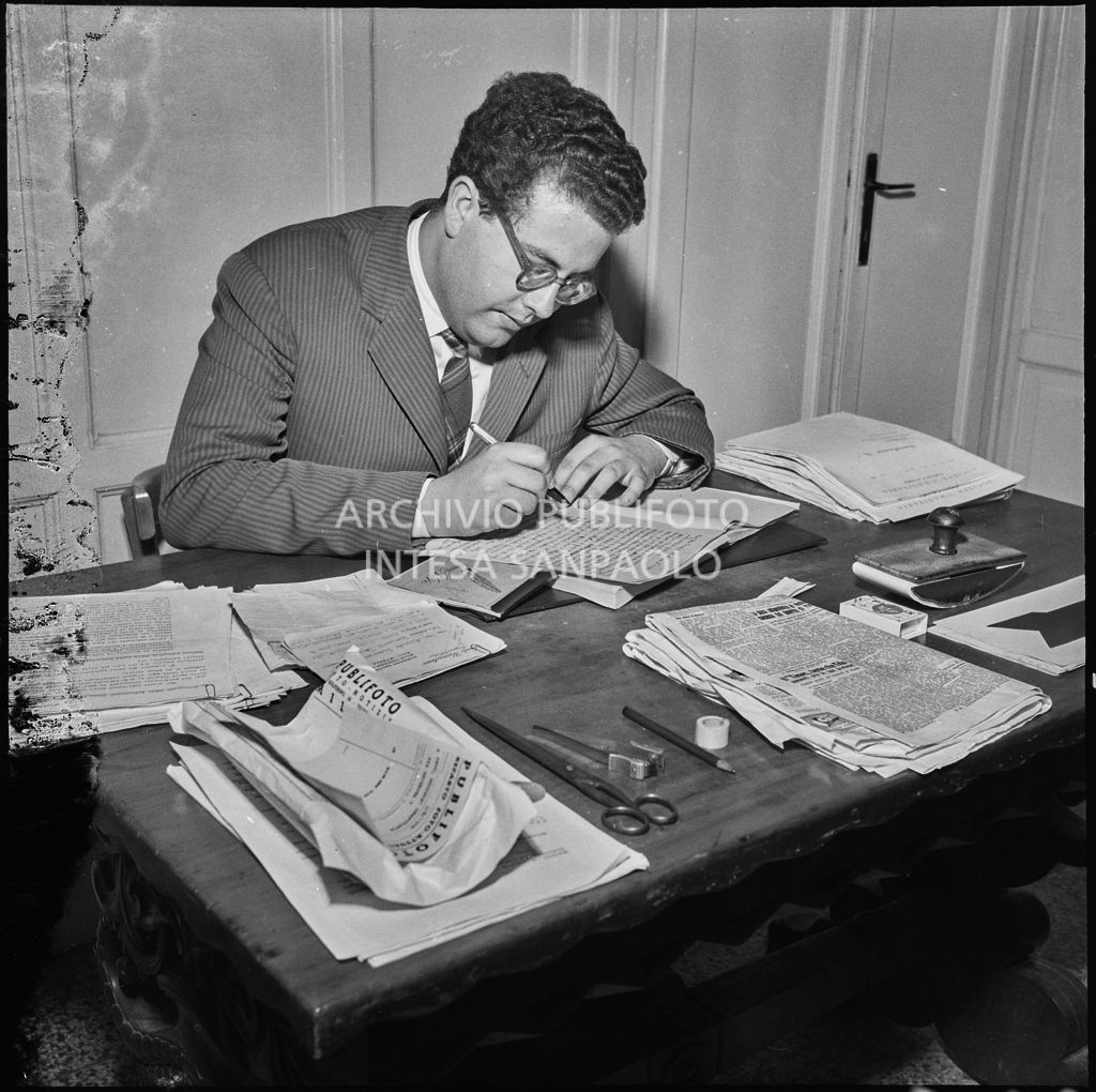 Un uomo seduto alla scrivania in occasione del convegno di studio sulle condizioni del lavoratore nell'impresa industriale organizzata nei Chiostri di San Barnaba a Milano dalla Società Umanitaria. Sulla scrivania una busta da lettere della Publifoto<br>216345