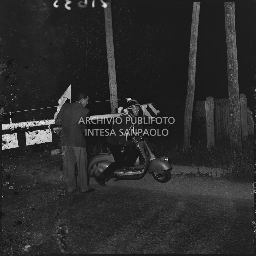 Un concorrente della competizione sportiva 1000 Km Vespistica del 1954 supera un passaggio a livello ferroviario<br>216352