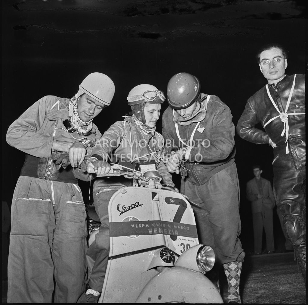 La concorrente del Vespa Club di Venezia (numero di gara 7) prende il tempo insieme ad altri concorrenti della competizione sportiva 1000 Km Vespistica del 1954<br>216357