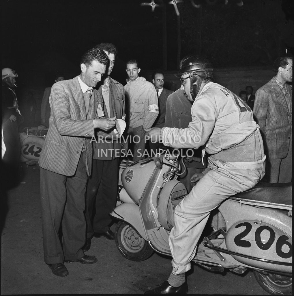 Controllo tempi di un concorrente (numero di gara 206) durante la competizione sportiva 1000 Km Vespistica del 1954<br>216374