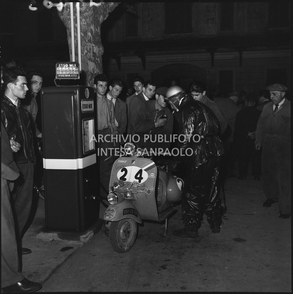 Il concorrente Rudy Aragno del Vespa Club di Parigi (numero di gara 24) effettua un rifornimento durante la competizione sportiva 1000 Km Vespistica del 1954<br>216403