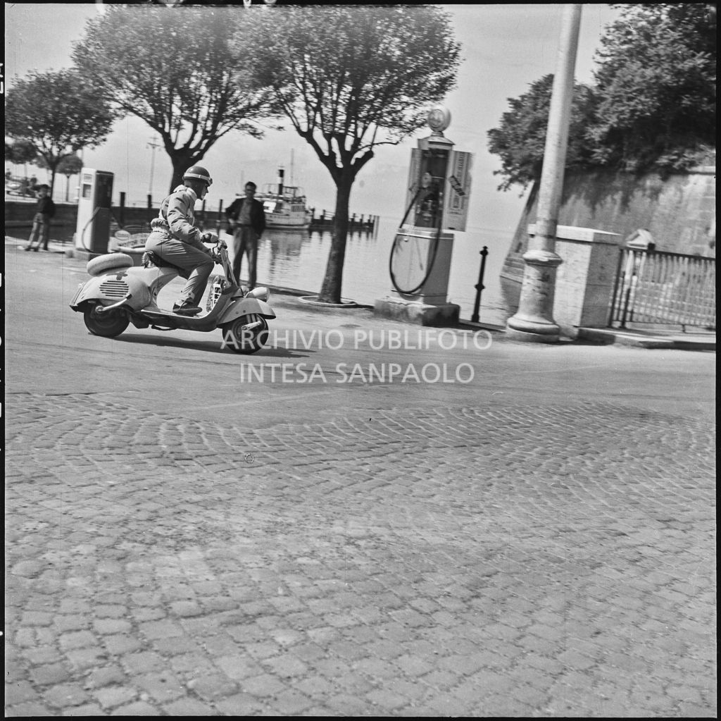 Una concorrente (numero di gara 4) a Peschiera del Garda durante la competizione sportiva 1000 Km Vespistica del 1954<br>216409