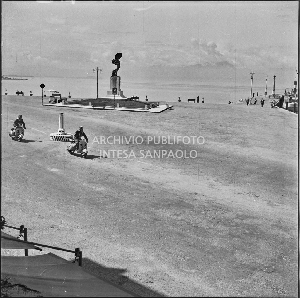 I concorrenti Osvaldo Buffarini del Vespa Club di Forlì (numero di gara 36) e Scmaaf del Vespa Club di Dusseldorf (numero di gara 29) a Peschiera del Garda durante la competizione sportiva 1000 Km Vespistica del 1954<br>216412