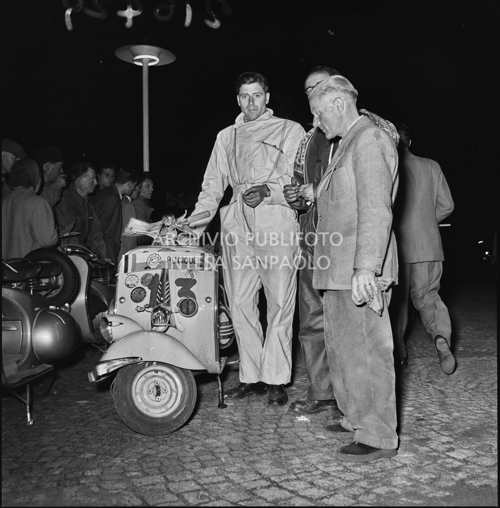 Un concorrente belga (numero di gara 13) della competizione sportiva 1000 Km Vespistica del 1954 durante un momento di pausa<br>216429