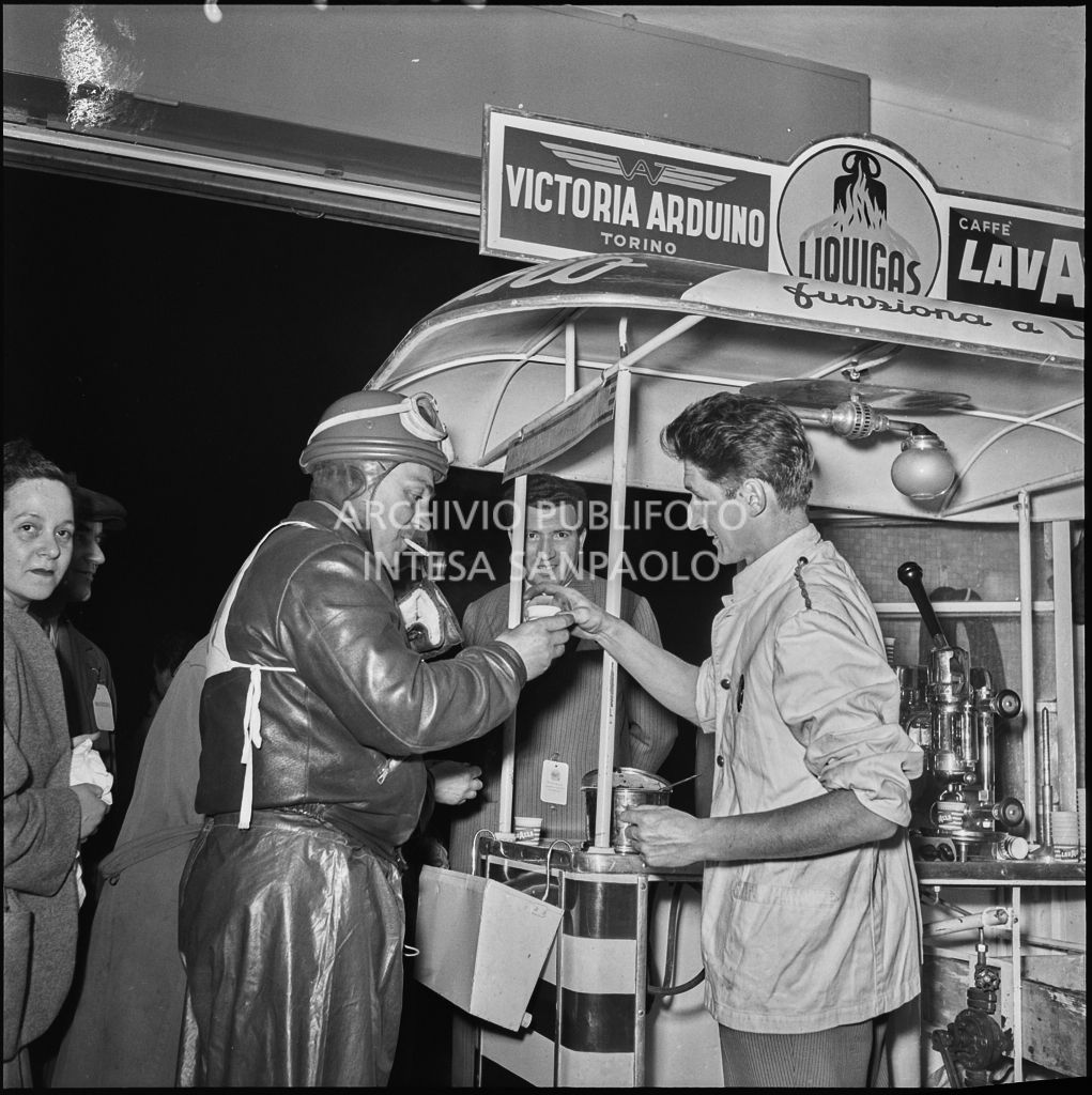Un concorrente beve un caffè di pausa dalla competizione sportiva 1000 Km Vespistica del 1954<br>216439
