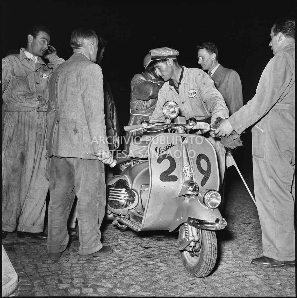 Controllo della Vespa del concorrente Scmaaf del Vespa club di Dusseldorf (numero di gara 29) da parte di un meccanico della Esso durante una pausa dalla competizione sportiva 1000 Km Vespistica del 1954<br>216440