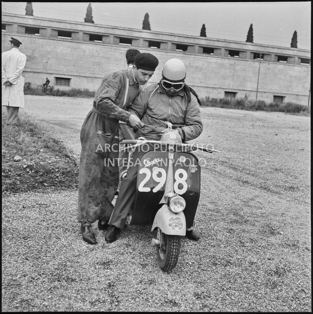 Il concorrente Enzo Garrirei del Vespa Club di Pietrasanta (numero di gara 298) controlla i tempi durante una pausa dalla competizione sportiva 1000 Km Vespistica del 1954<br>216452