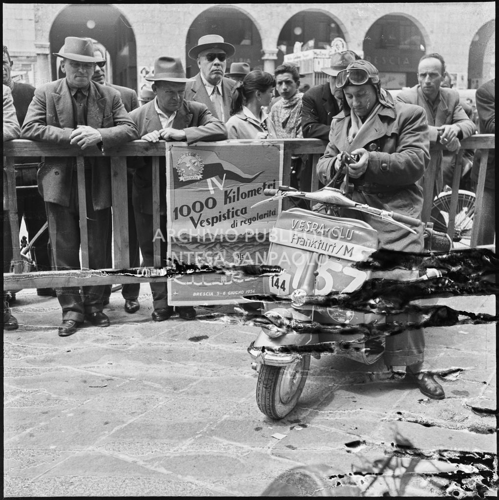 Un concorrente del Vespa Club di Francoforte (numero di gara 157) in piazza della Vittoria a Brescia in occasione della competizione sportiva 1000 Km Vespistica del 1954<br>216454