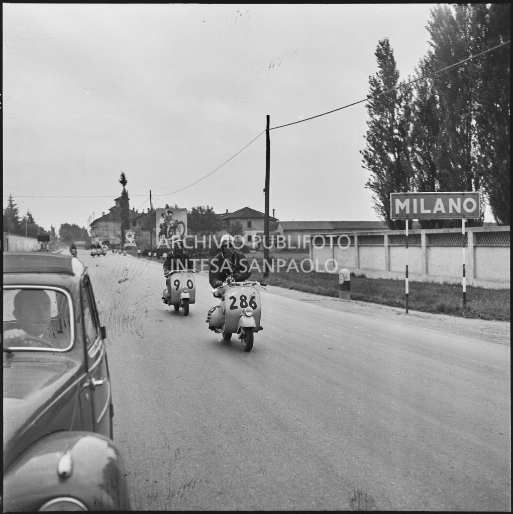 Due concorrenti (numero di gara 286 e 90) a Milano durante la competizione sportiva 1000 Km Vespistica del 1954<br>216462