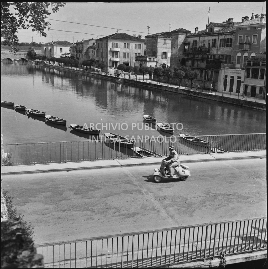 Un concorrente del Vespa Club di Verona (numero di gara 4) durante la competizione sportiva 1000 Km Vespistica del 1954 a Peschiera del Garda<br>216468