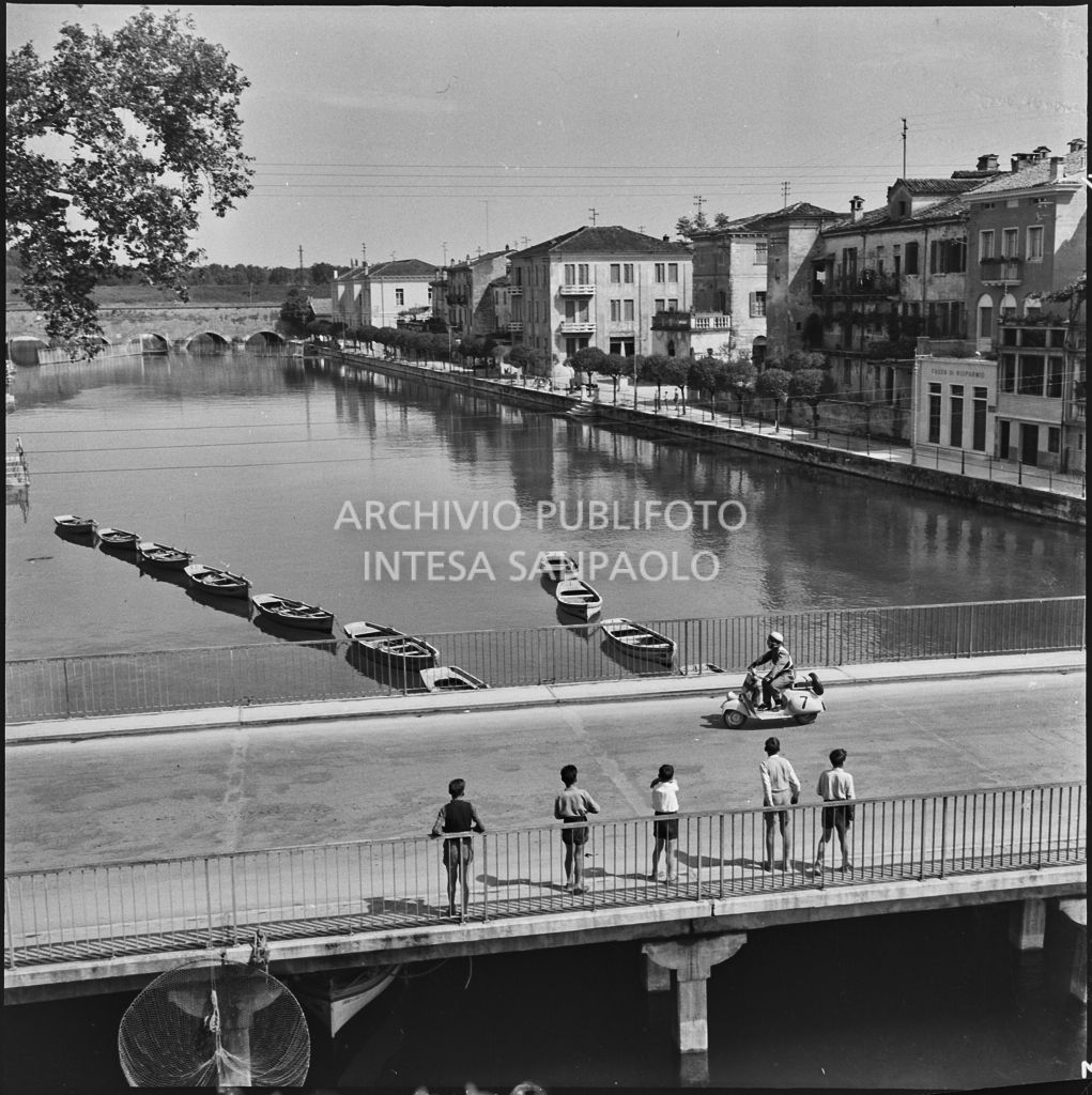 Un concorrente del Vespa Club di Mestre (numero di gara 7) durante la competizione sportiva 1000 Km Vespistica del 1954 a Peschiera del Garda<br>216470