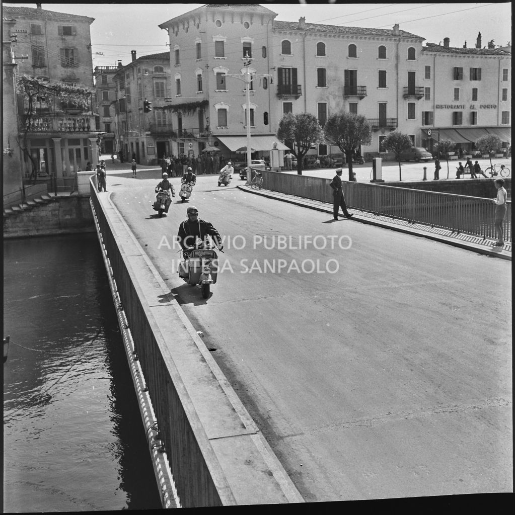 Alcuni concorrenti durante la competizione sportiva 1000 Km Vespistica del 1954 a Peschiera del Garda<br>216478