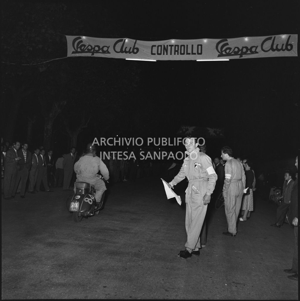 Arrivo di un concorrente (numero di gara 84) al controllo tempi della competizione sportiva 1000 Km Vespistica del 1954<br>216487