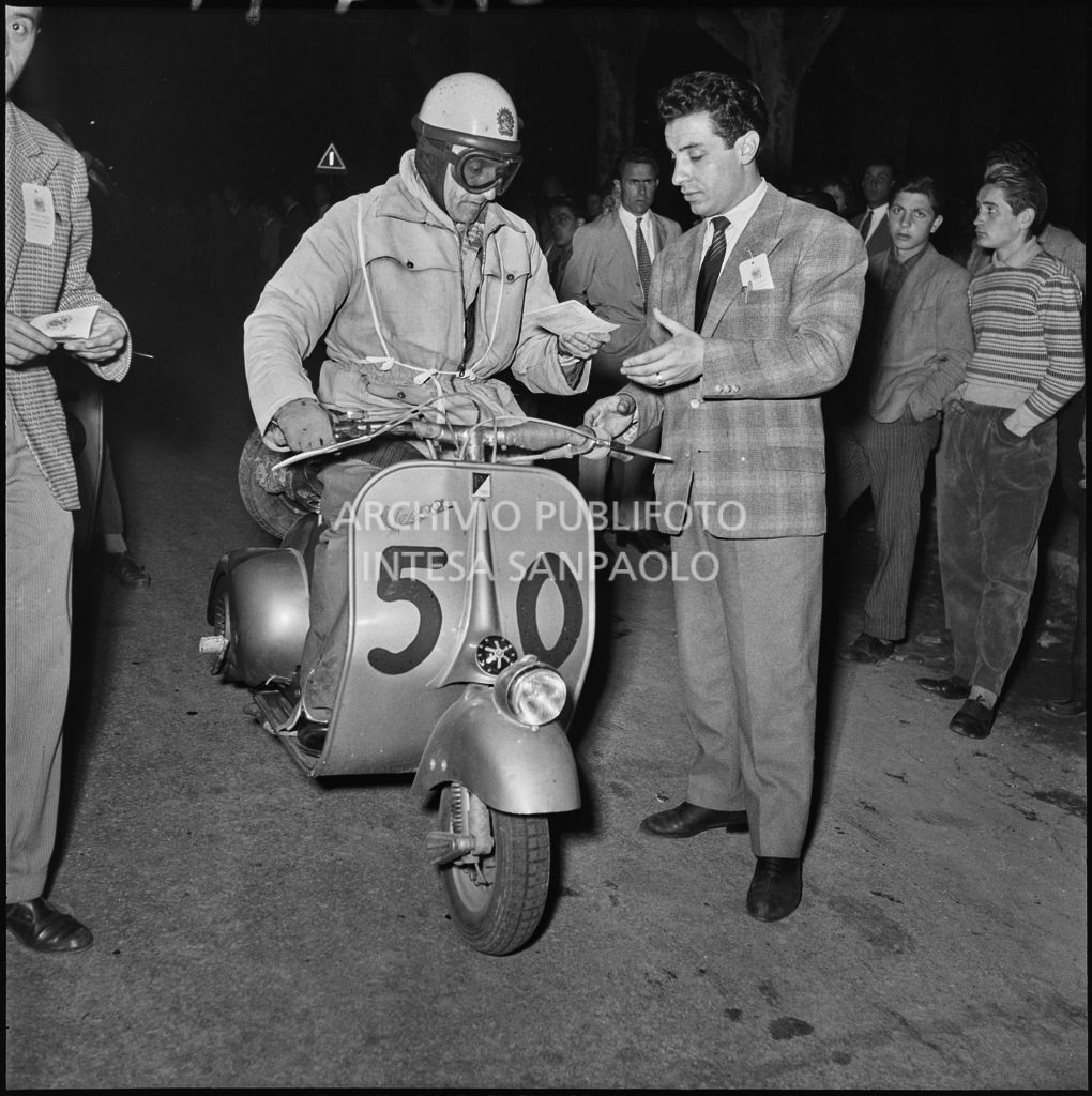 Arrivo di un concorrente del Vespa Club di Brescia (numero di gara 50) al controllo tempi della competizione sportiva 1000 Km Vespistica del 1954<br>216491