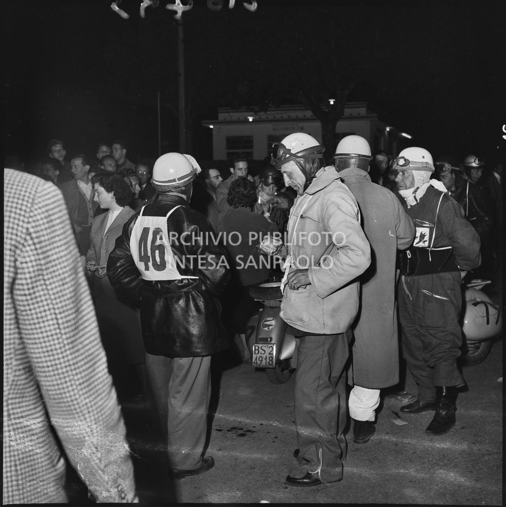 Il concorrete Italo Mosca del Vespa Club di Brescia (numero di gara 46) in compagnia di altri concorrenti durante una pausa dalla competizione sportiva 1000 Km Vespistica del 1954<br>216493