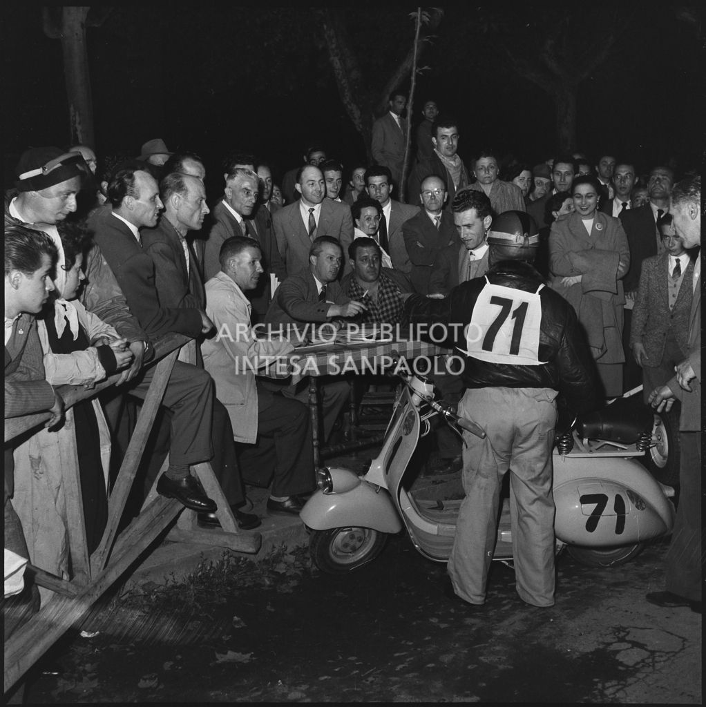 Arrivo di un concorrente (numero di gara 71) al controllo tempi della competizione sportiva 1000 Km Vespistica del 1954<br>216497