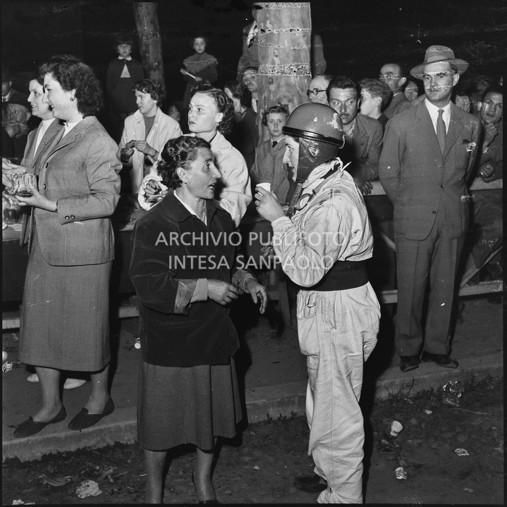 Una concorrente conversa con una signora durante una pausa dalla competizione sportiva 1000 Km Vespistica del 1954<br>216523