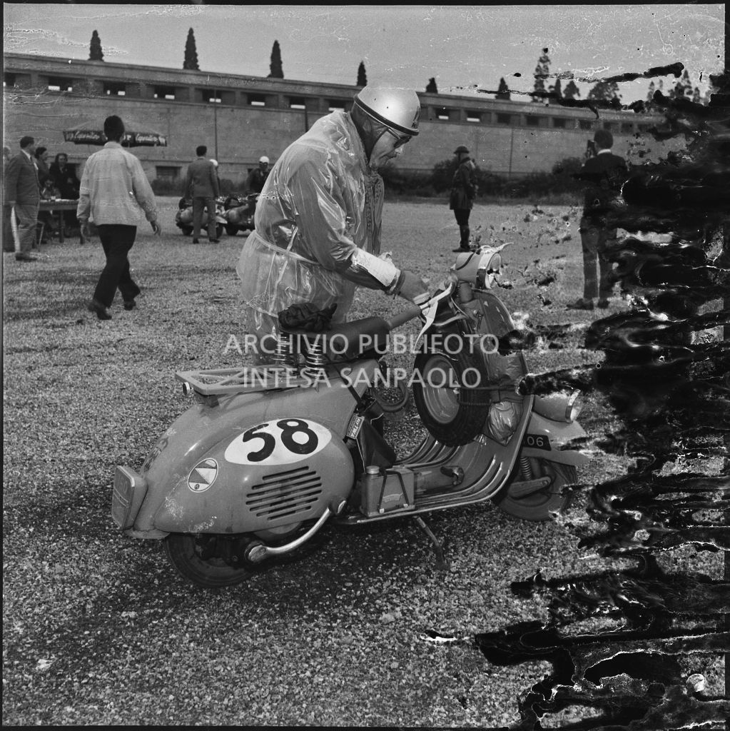 Un concorrente del Vespa Club di Nizza (numero di gara 58) durante una pausa dalla competizione sportiva 1000 Km Vespistica del 1954<br>216544
