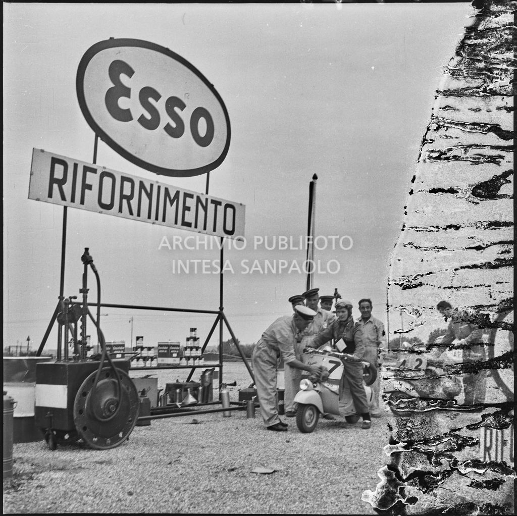 Un meccanico pulisce la Vespa di una concorrente del Vespa Club di Mestre (numero di gara 7) durante una pausa dalla competizione sportiva 1000 Km Vespistica del 1954<br>216548