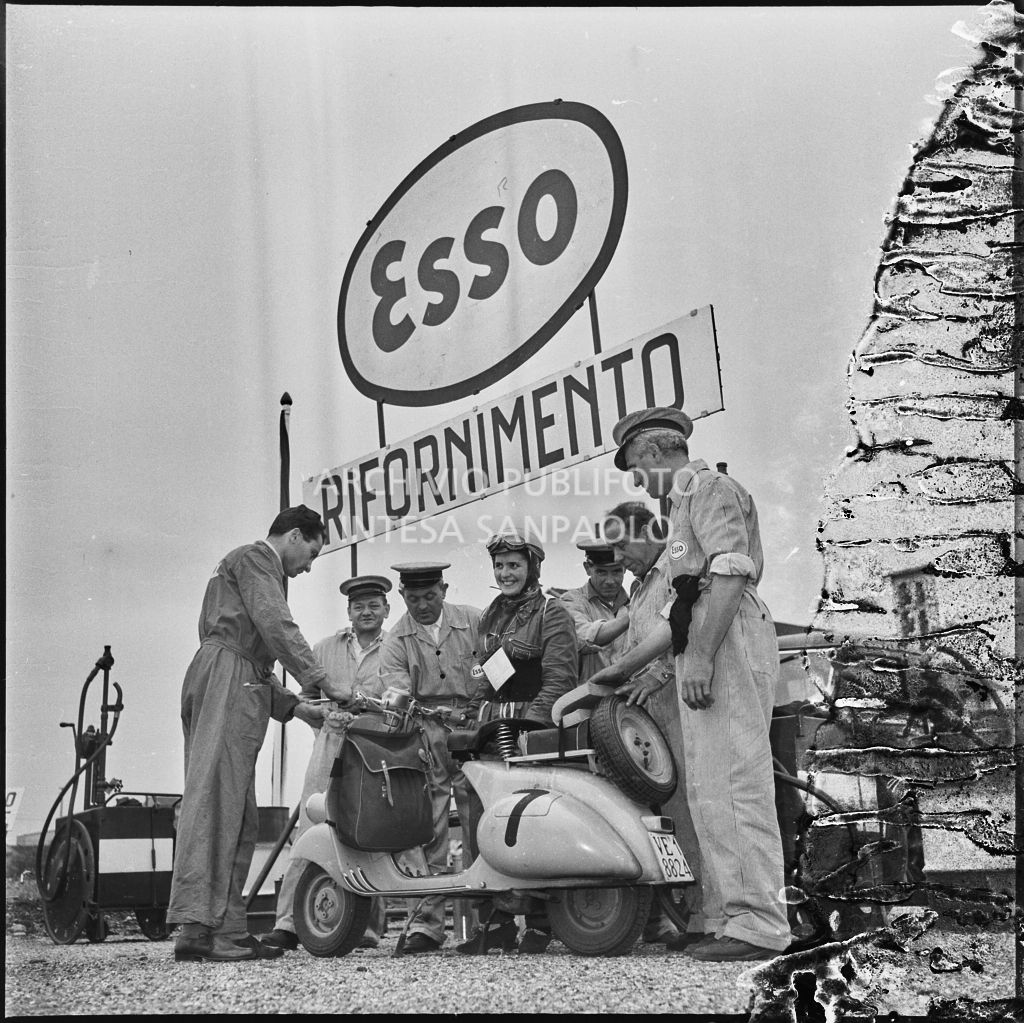 Una concorrente del Vespa Club di Mestre (numero di gara 7) con alcuni meccanici al punto rifornimento della competizione sportiva 1000 Km Vespistica del 1954<br>216551