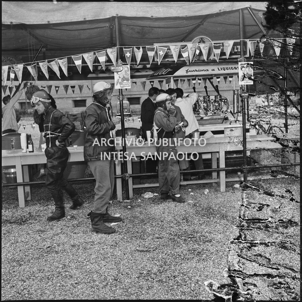 Alcuni concorrenti al punto ristoro durante una pausa dalla competizione sportiva 1000 Km Vespistica del 1954<br>216554