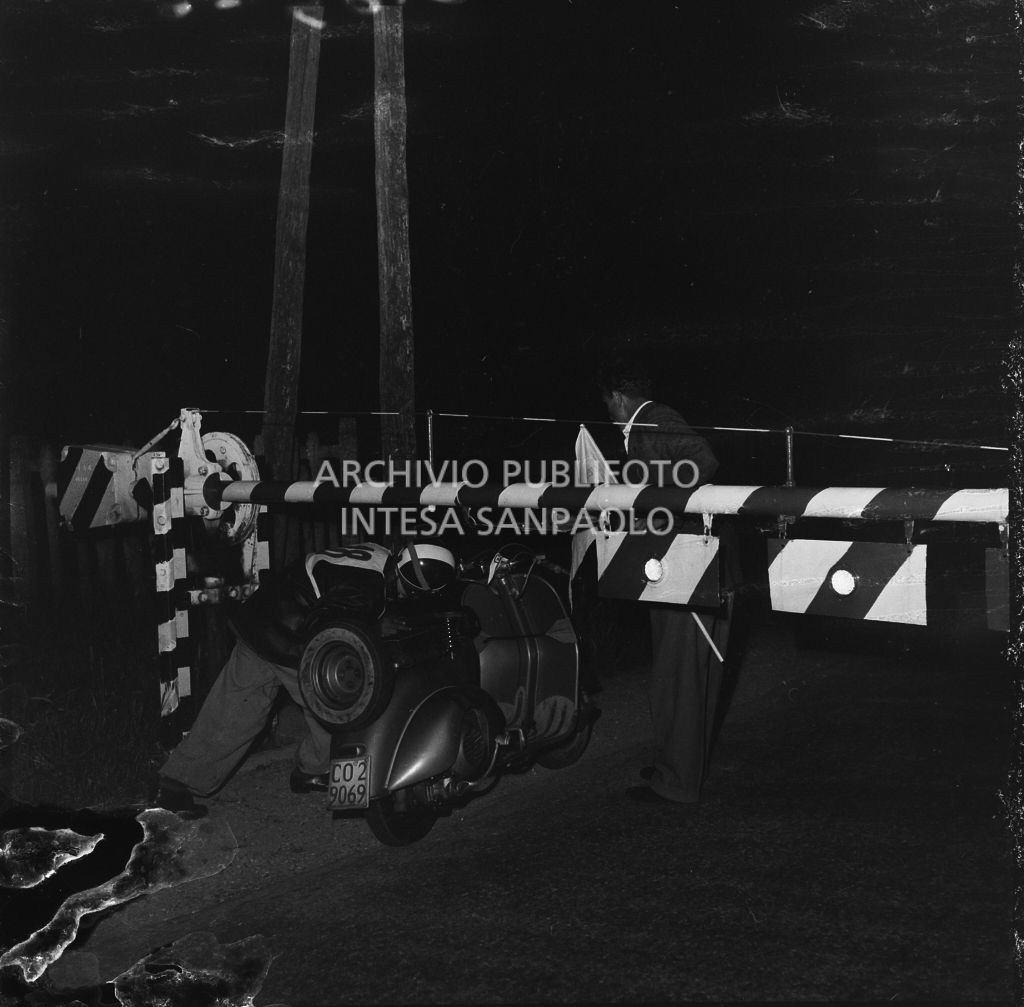 Un concorrente della competizione sportiva 1000 Km Vespistica del 1954 supera un passaggio a livello ferroviario<br>216566