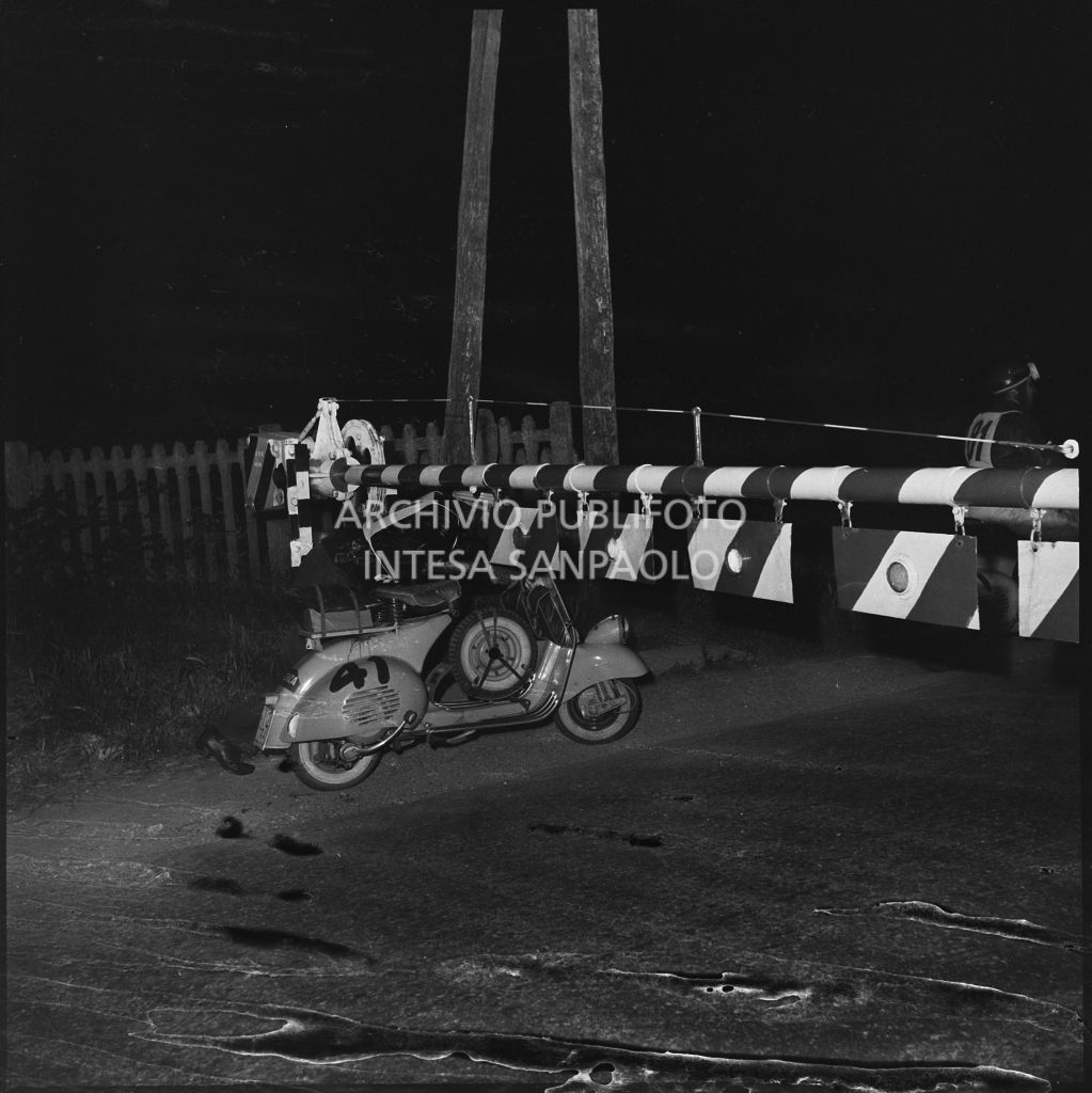 Il concorrente Emilio Gasparotto del Vespa Club di Vicenza (numero di gara 41) supera un passaggio a livello ferroviario durante la competizione sportiva 1000 Km Vespistica del 1954<br>216568