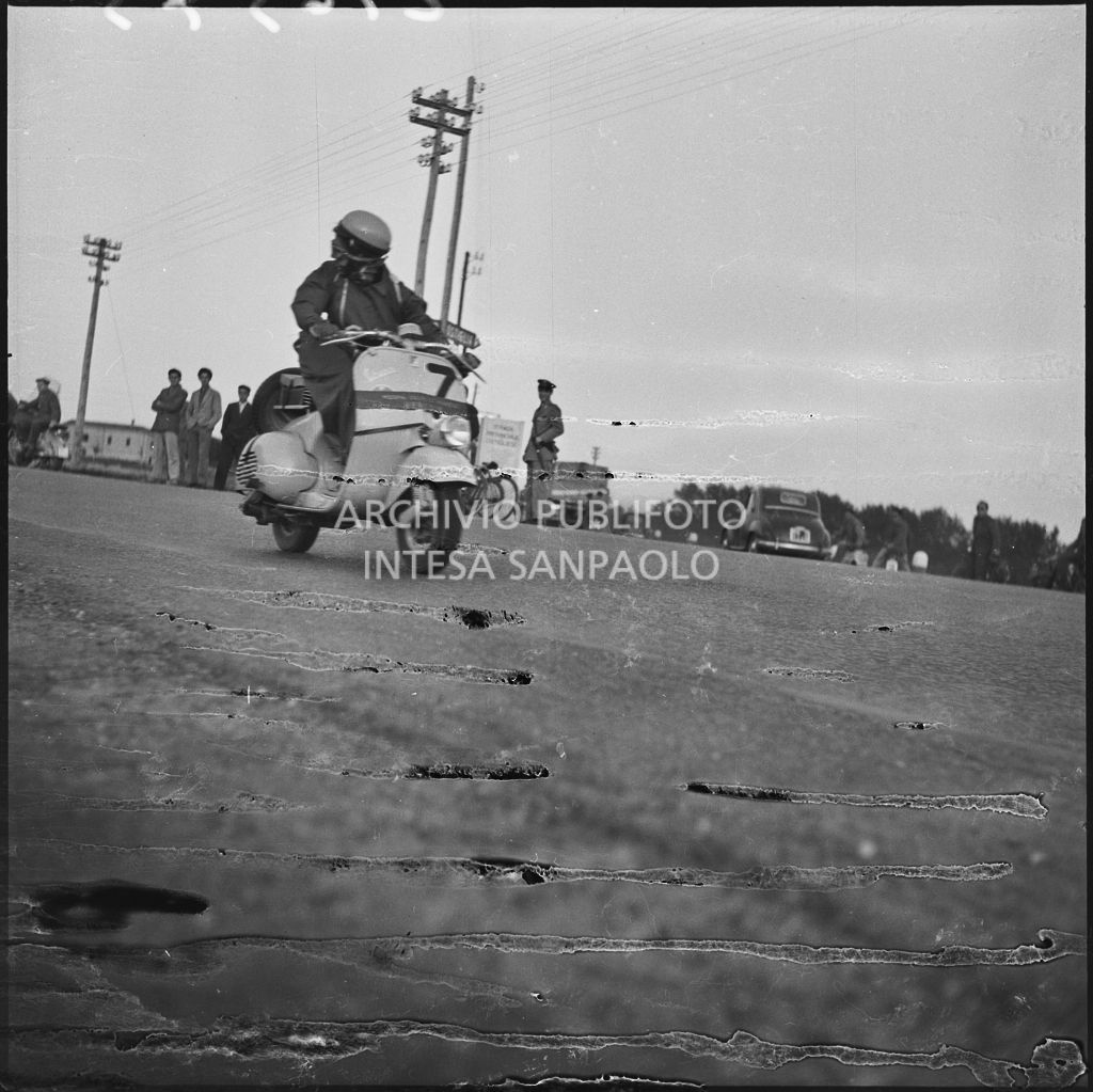 Una concorrente del Vespa Club di Mestre (numero di gara 7) durante la competizione sportiva 1000 Km Vespistica del 1954<br>216575
