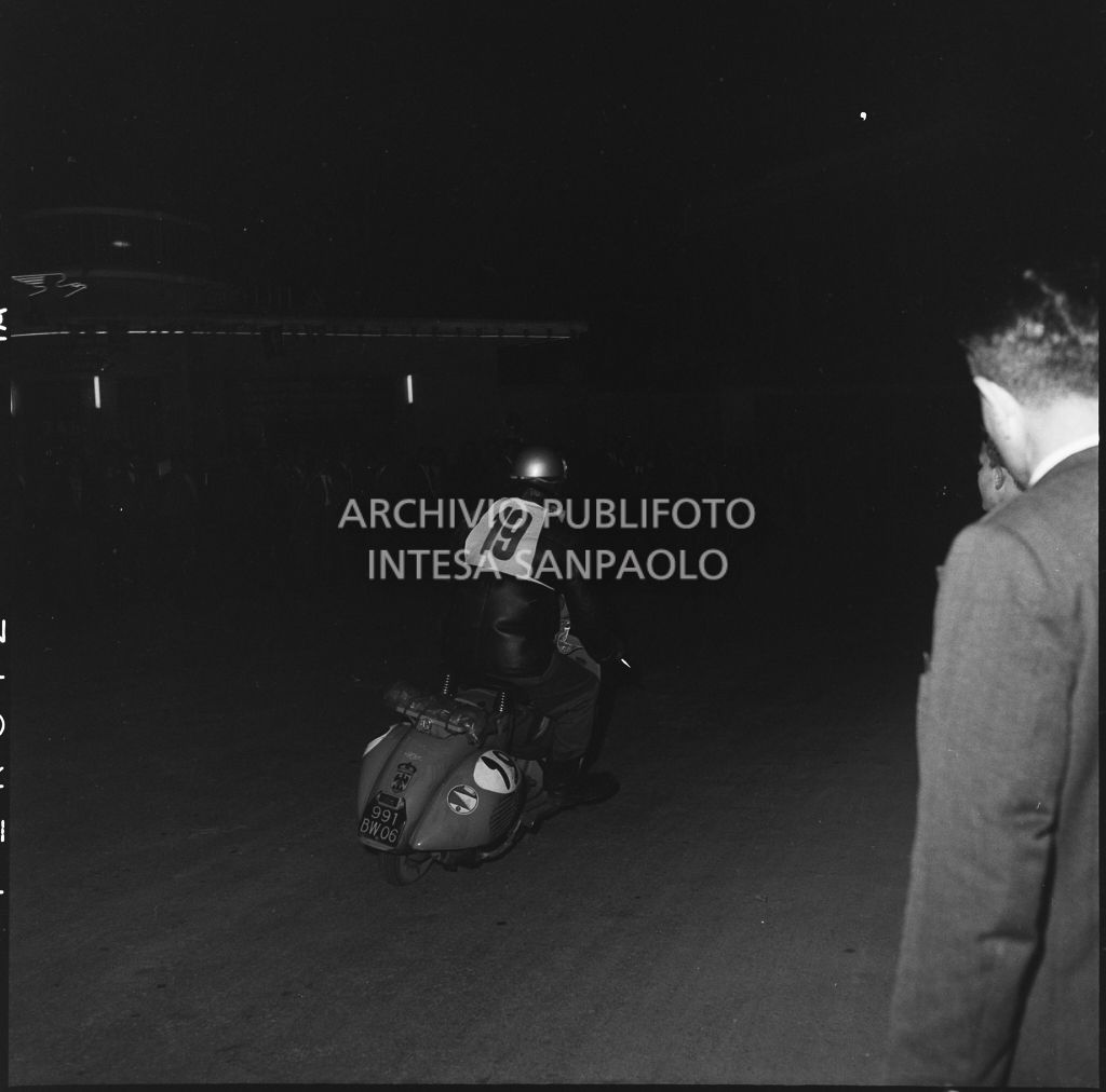 Il concorrente Vaucher del Vespa Club di Parigi (numero di gara 19) durante la competizione sportiva 1000 Km Vespistica del 1954<br>216605