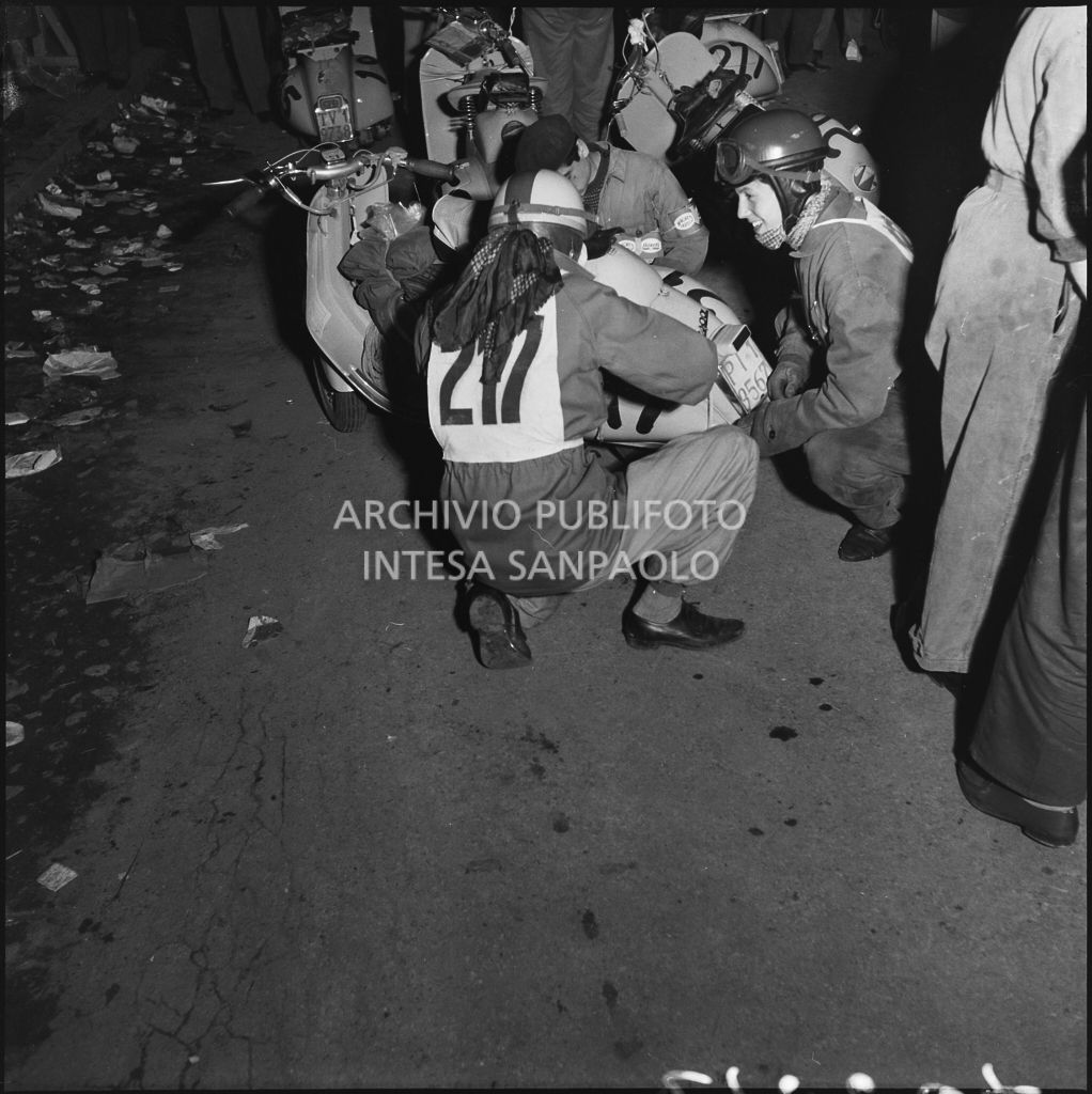 Un concorrente (numero di gara 217) controlla la sua Vespa durante una pausa dalla competizione sportiva 1000 Km Vespistica del 1954<br>216607