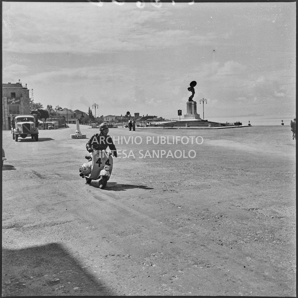 Il concorrente Ugo Miazzi del Vespa Club di Trieste (numero di gara 44) a Peschiera del Garda durante la competizione sportiva 1000 Km Vespistica del 1954<br>216610