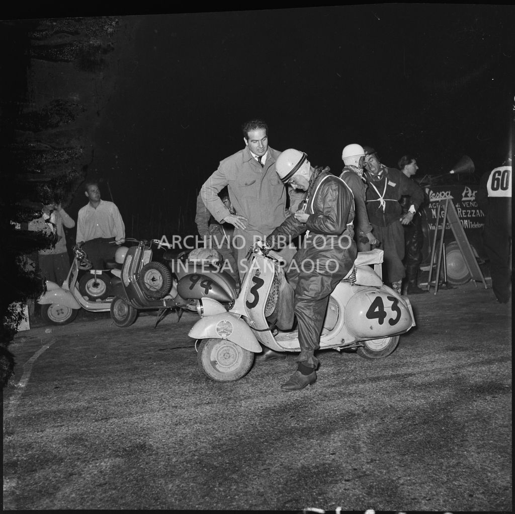 Il concorrente Claudio Zalvini del Vespa Club di Ancona (numero di gara 43)controlla i tempi durante una pausa della competizione sportiva 1000 Km Vespistica del 1954<br>216640