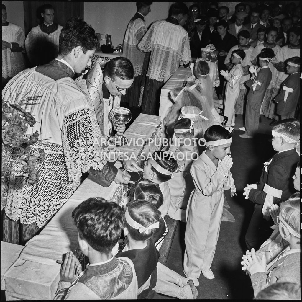 I bambini dell'Istituto Leone XIII di Milano, in ginocchio davanti all'altare, ricevono il sacramento della Comunione<br>216876