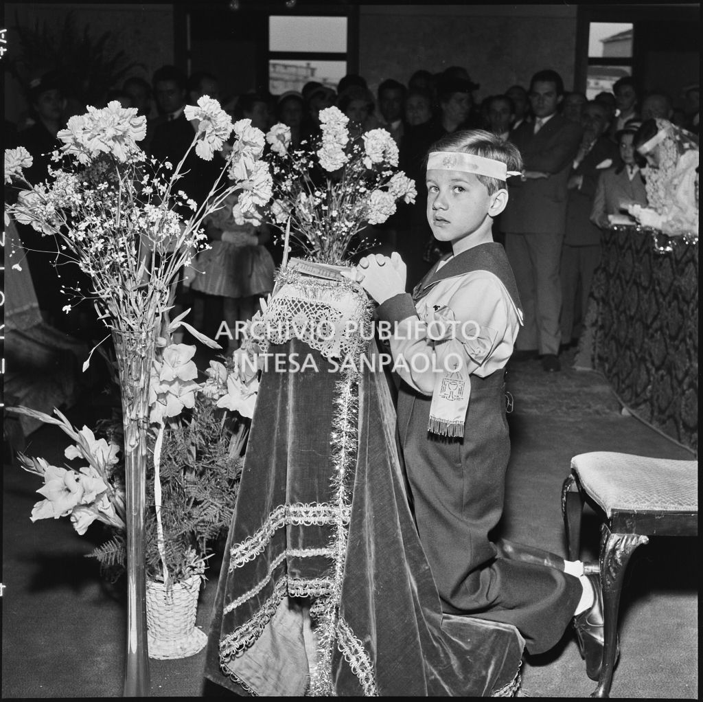 Un bambino dell'Istituto Leone XIII di Milano, in ginocchio davanti all'altare, in occasione della celebrazione del sacramento della Comunione<br>216877