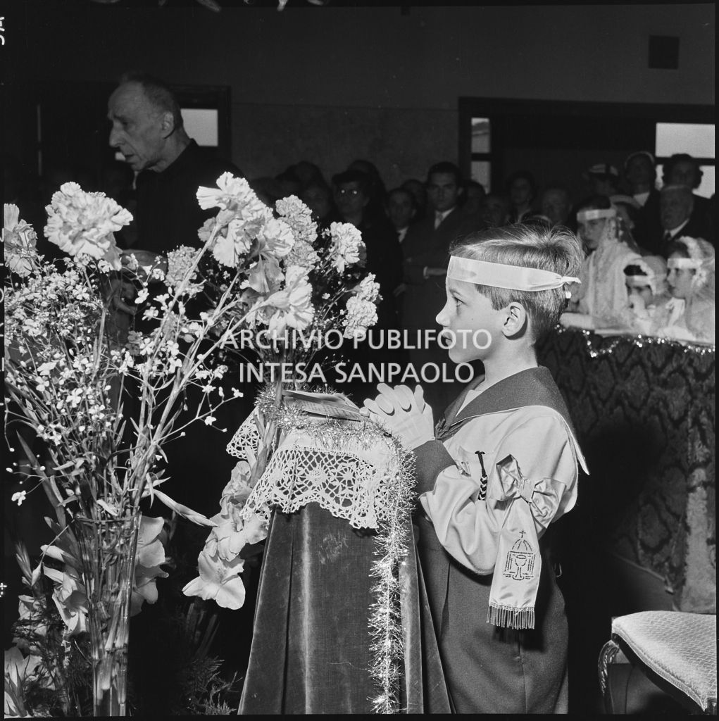 Un bambino dell'Istituto Leone XIII di Milano, in ginocchio davanti all'altare, in occasione della celebrazione del sacramento della Comunione<br>216880
