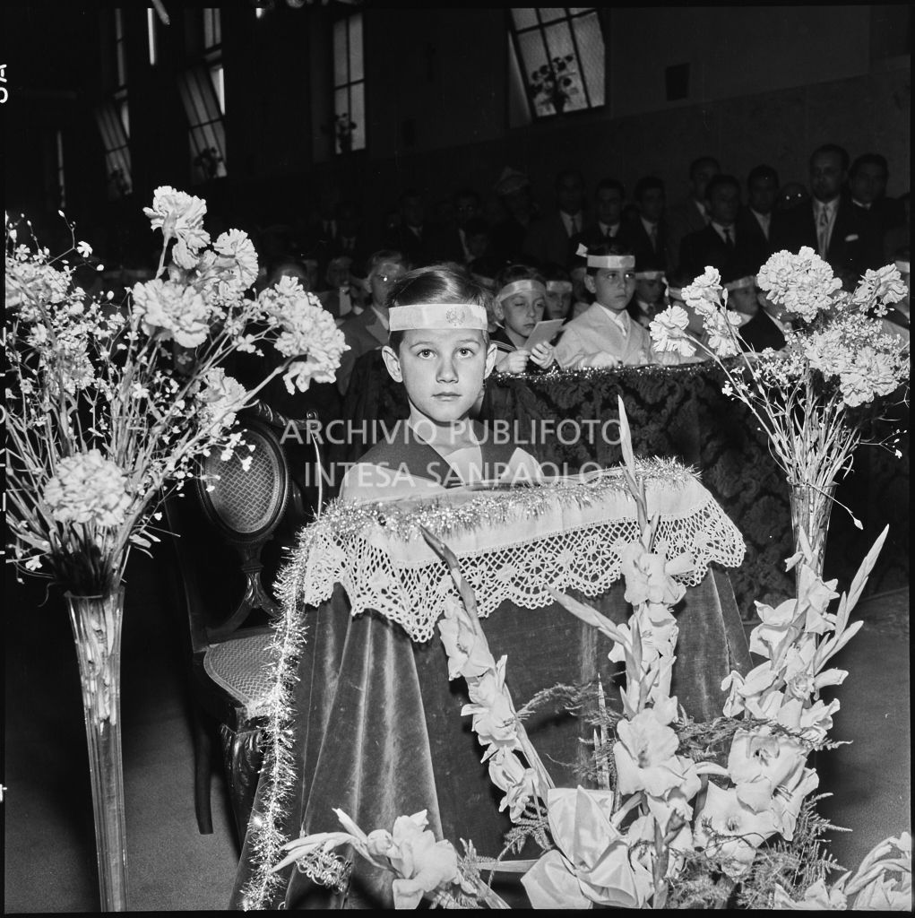 Un bambino dell'Istituto Leone XIII di Milano, in ginocchio davanti all'altare, in occasione della celebrazione del sacramento della Comunione<br>216881