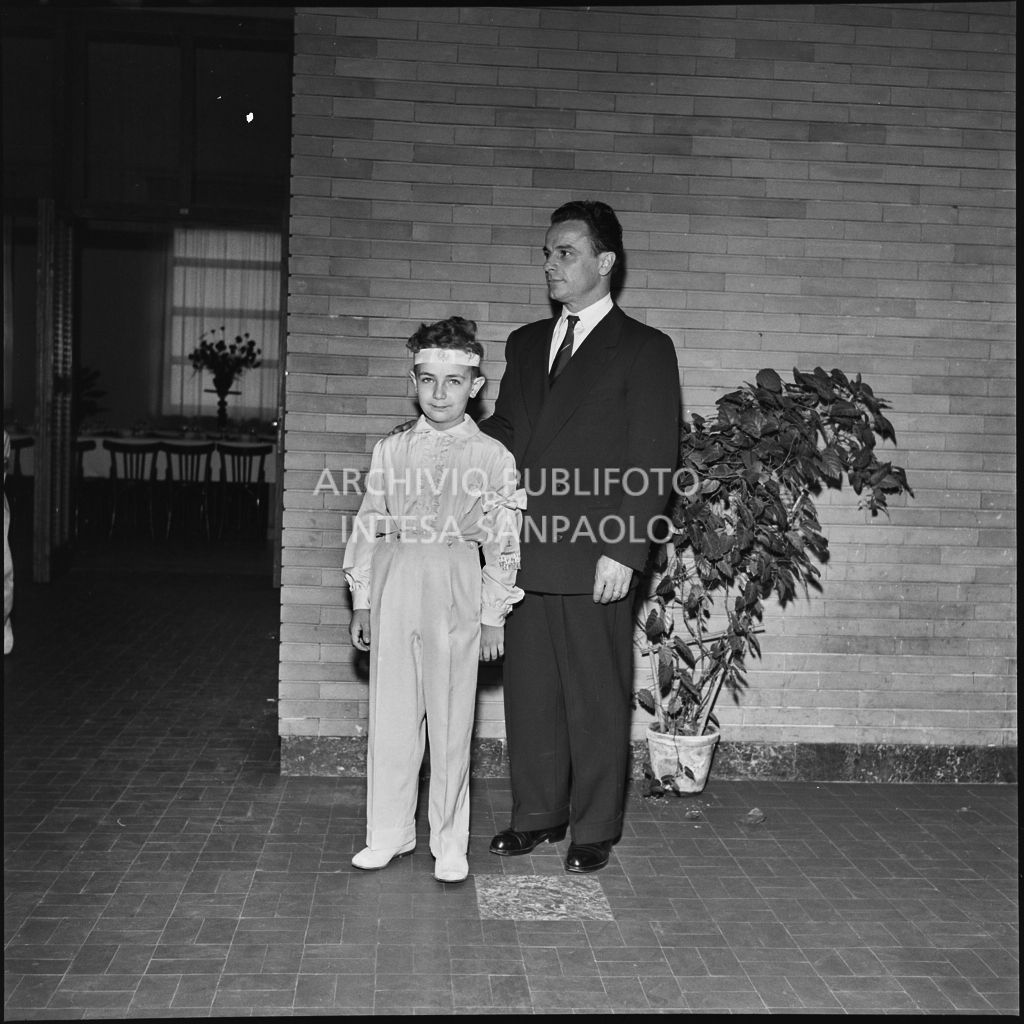 Un bambino dell'Istituto Leone XIII di Milano con un uomo in occasione della celebrazione del sacramento della Comunione<br>216887