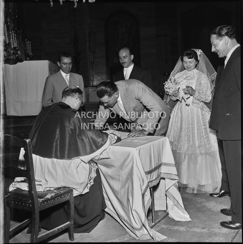 Un testimone del dottor Della Croce firma il registro parrocchiale al termine del matrimonio celebrato nella Chiesa di San Protaso in via Osoppo a Milano<br>217470