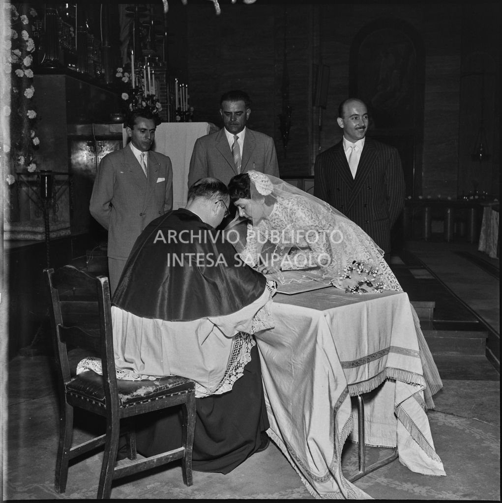 La sposa del dottor Della Croce firma il registro parrocchiale al termine del matrimonio celebrato nella Chiesa di San Protaso in via Osoppo a Milano<br>217471